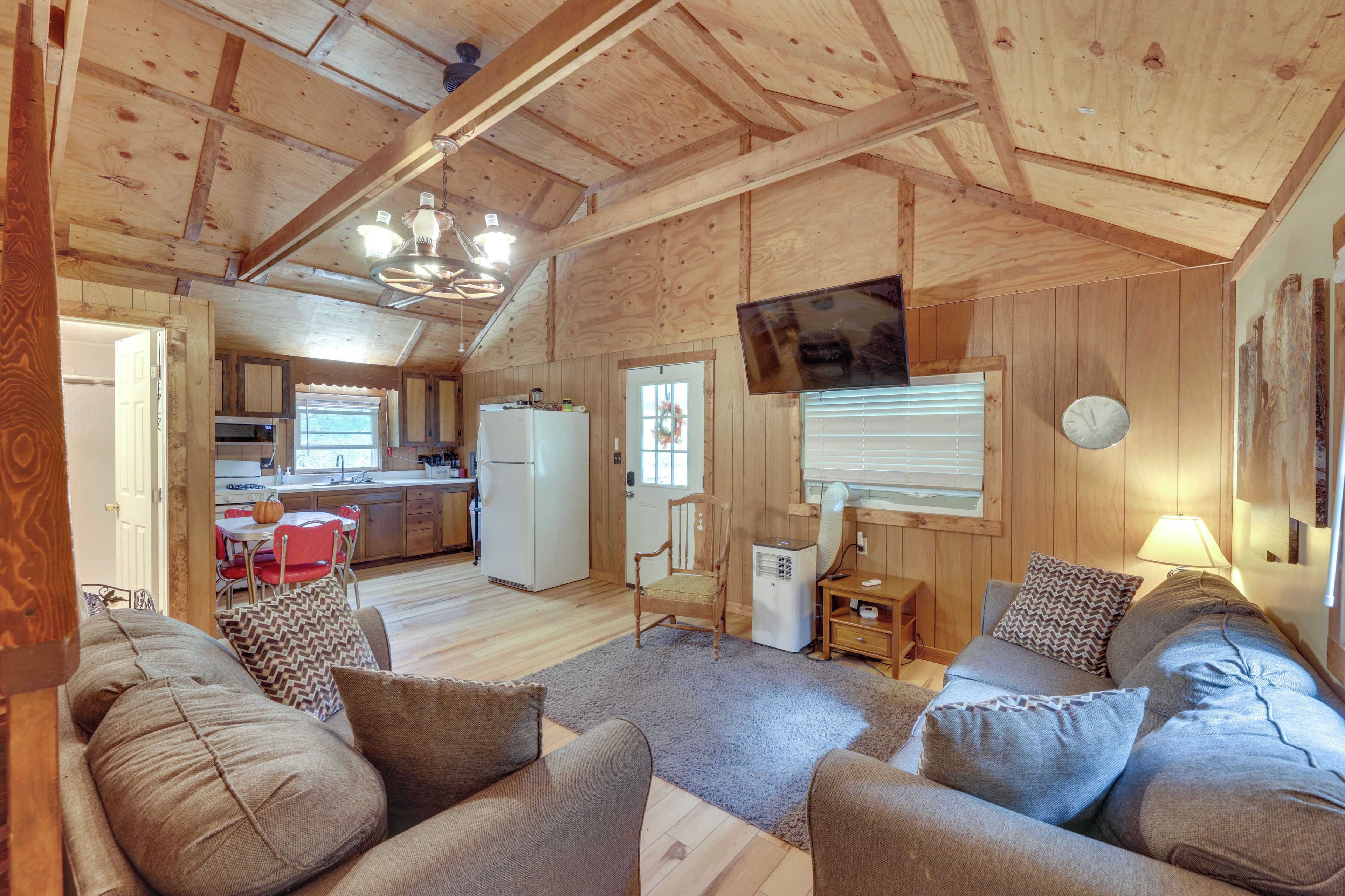 A spacious living room with a large sofa set, a dining area with a table and chairs, and a kitchen with modern appliances.