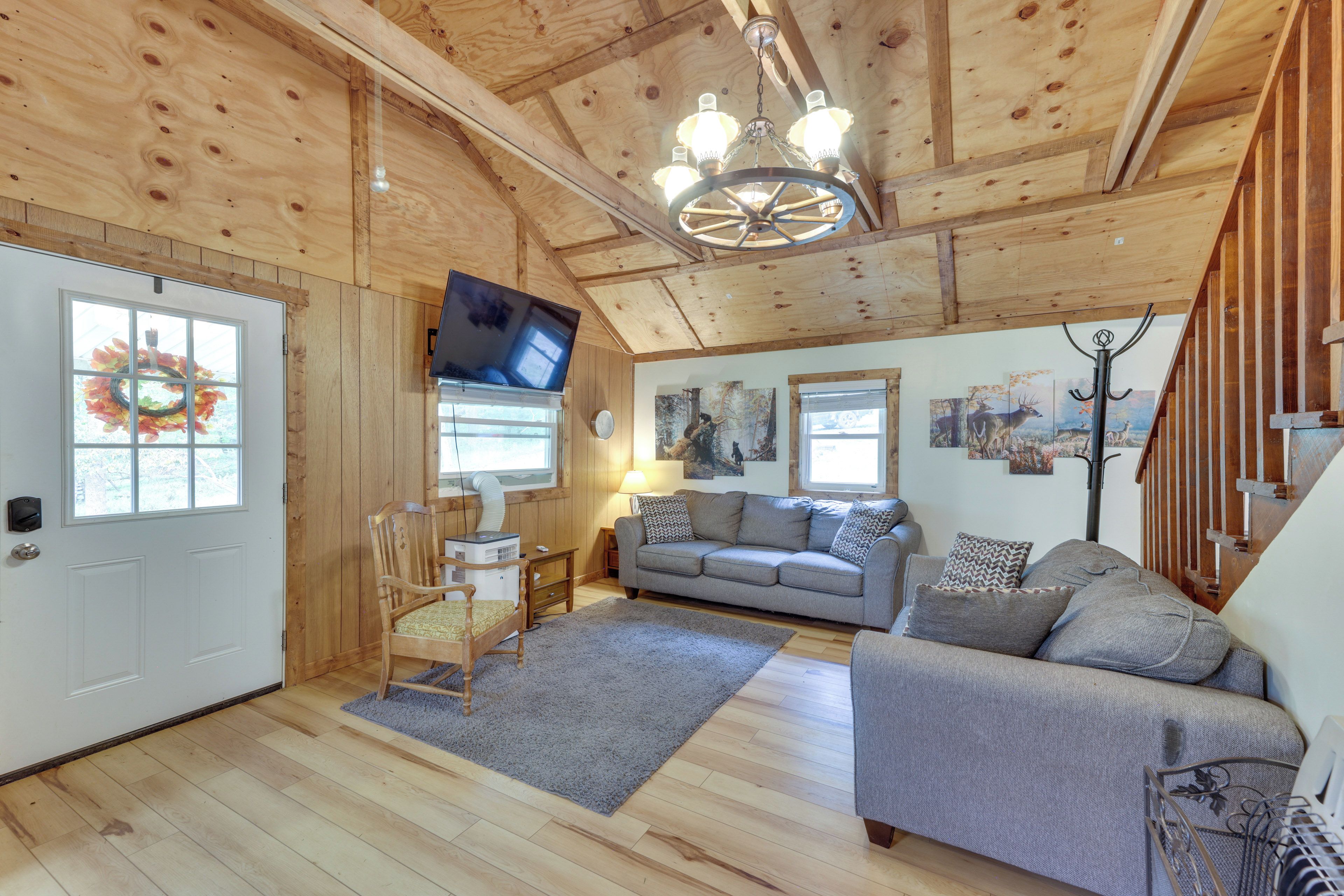 Un interior de madera con sofá, televisor y chimenea.