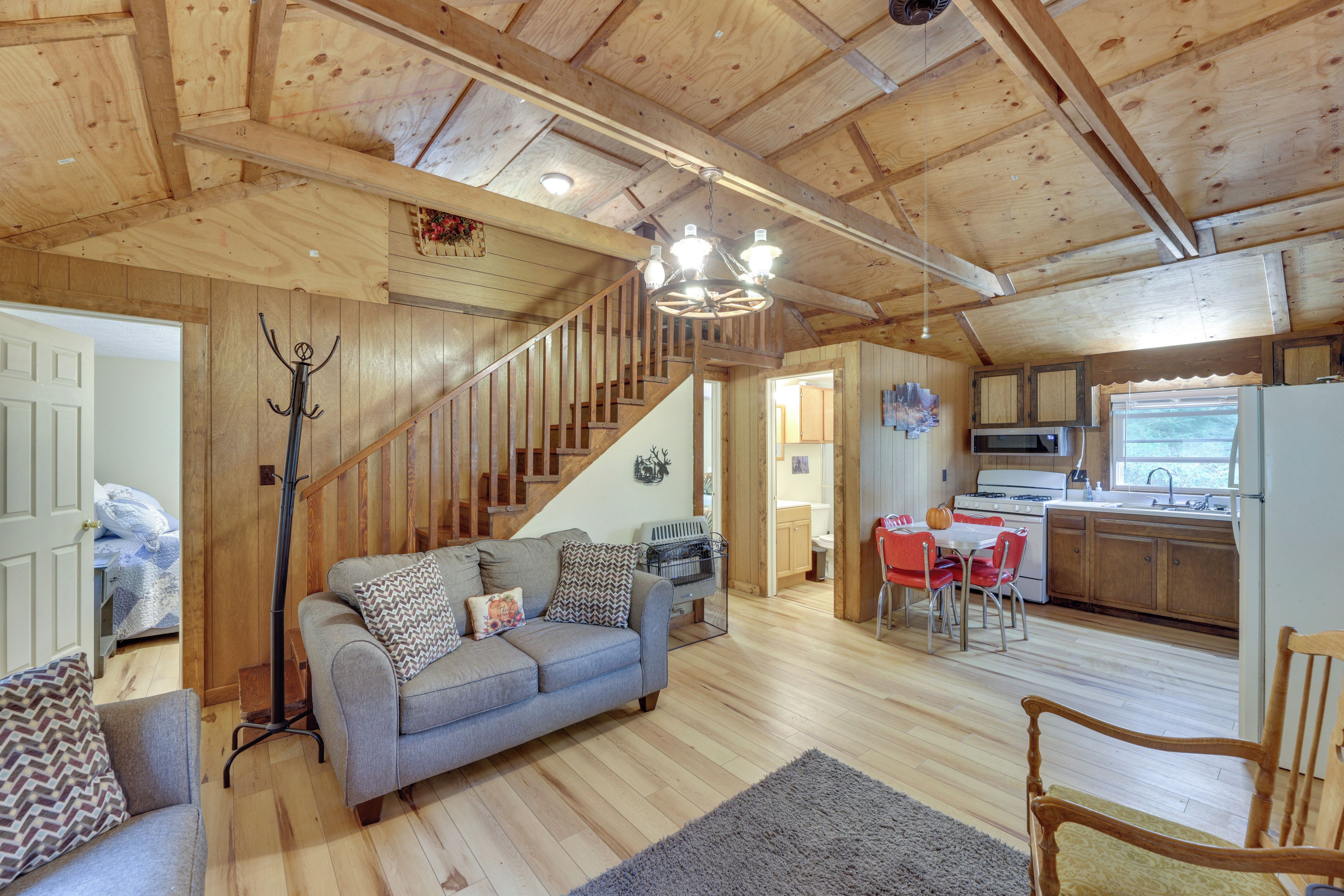 A wooden interior with a sofa, a dining table, and a kitchen area.