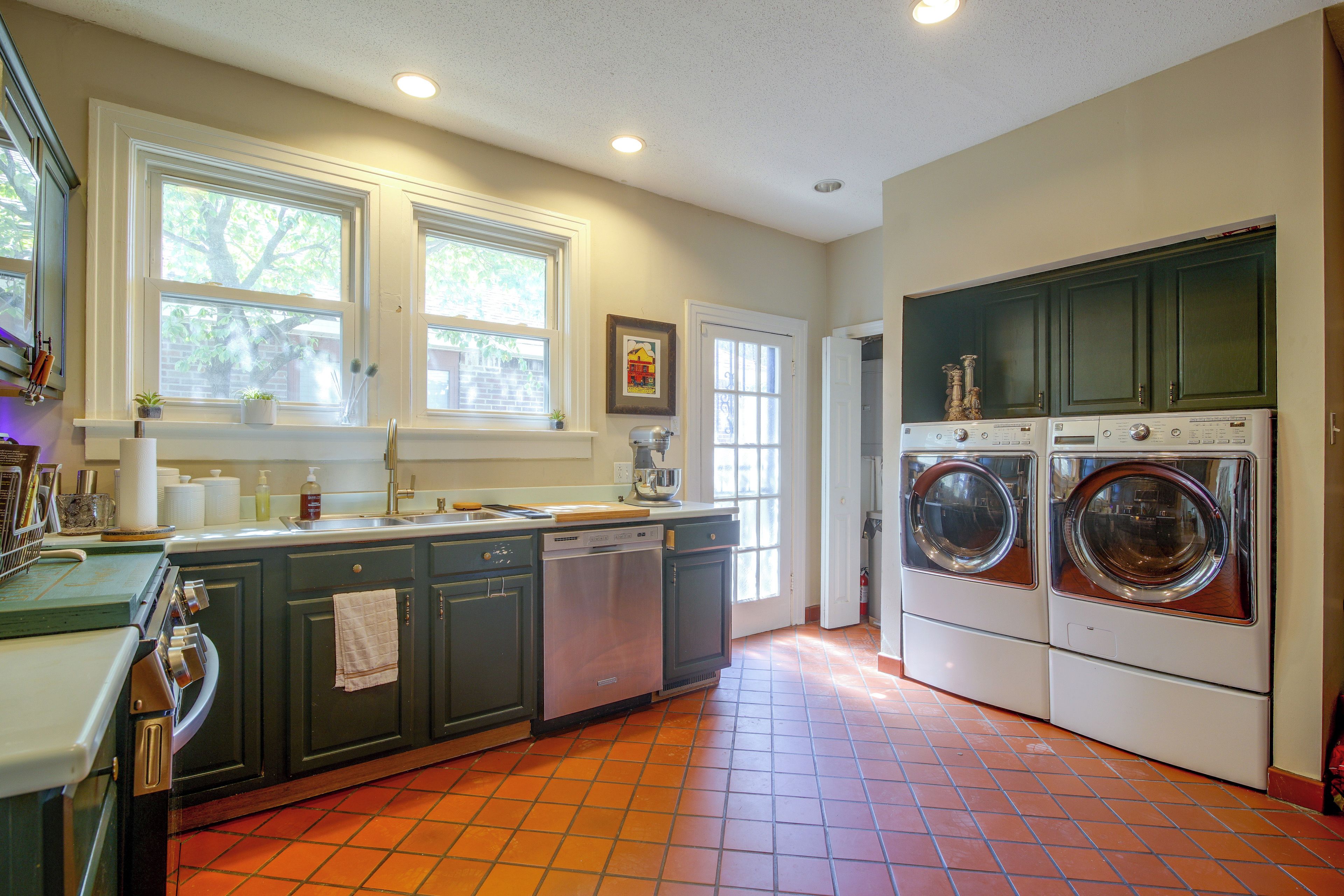 A laundry room with two washing machines, a dishwasher, and a sink.
