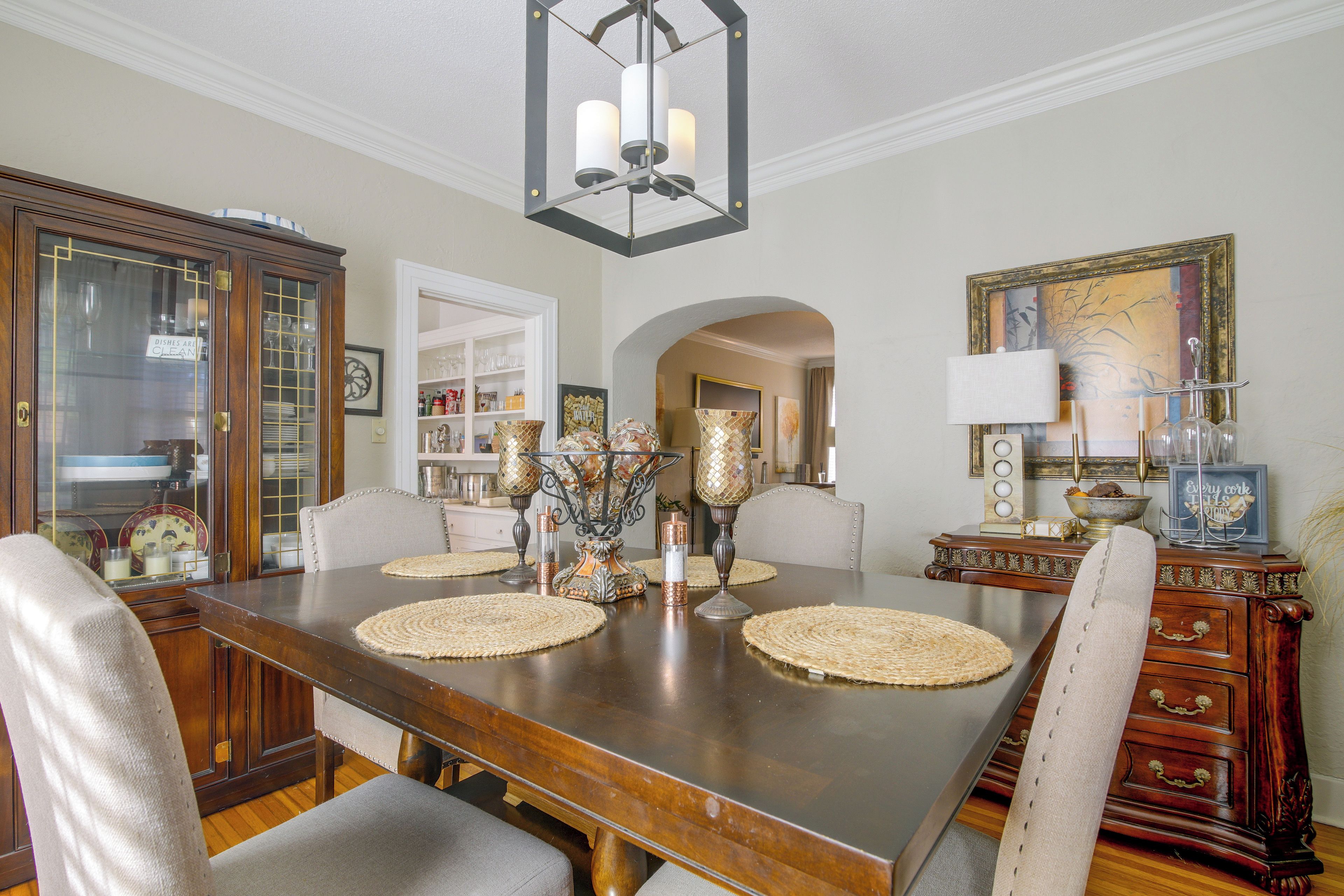 A dining room with a wooden table, chairs, and decorative items.