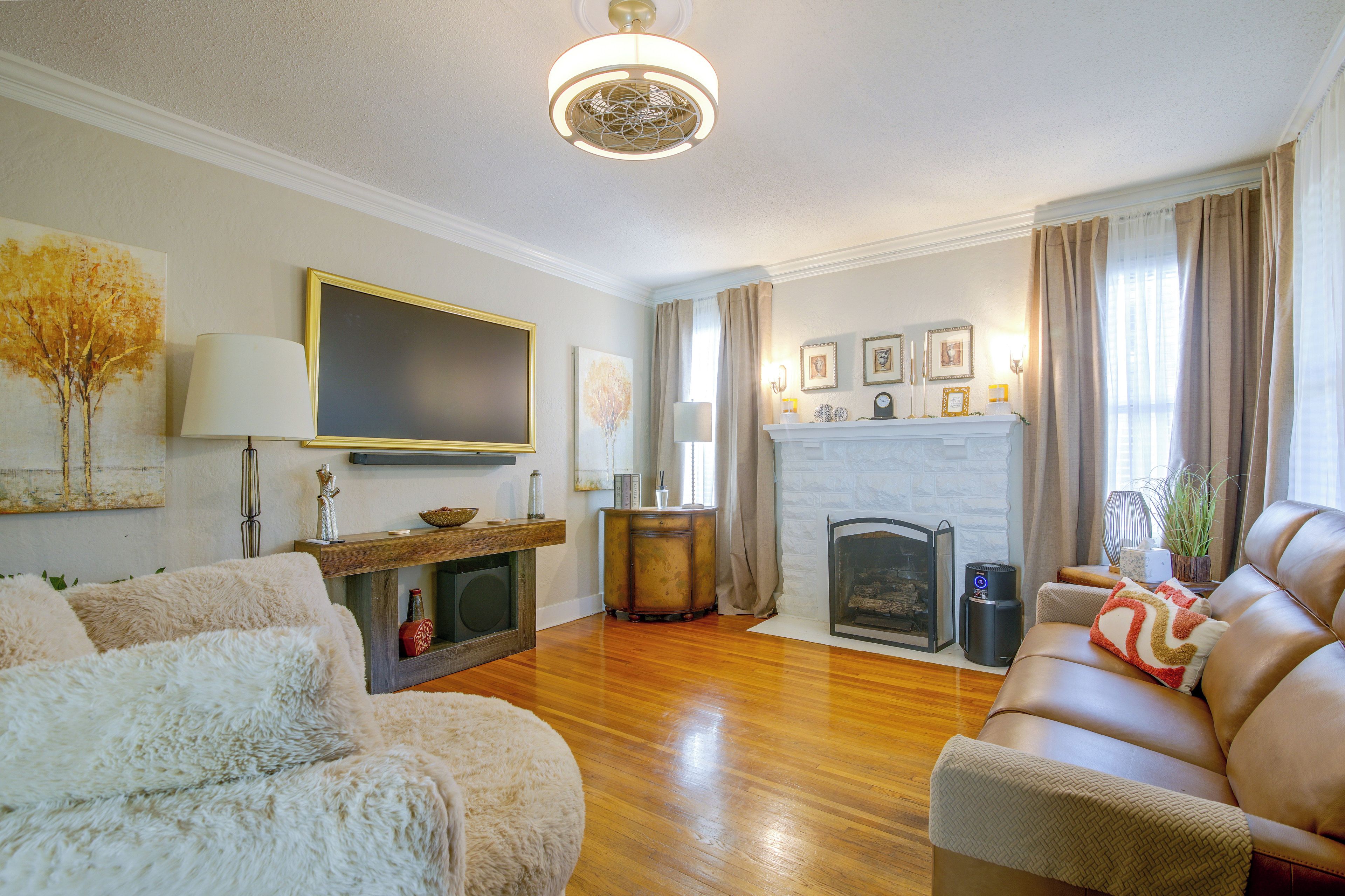 A living room with a fireplace, a sofa, a television, and a decorative wall.