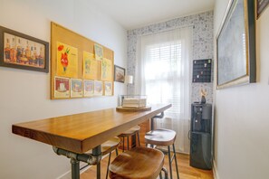 A room with a wooden table, a chair, a water dispenser, and a bulletin board with various posters. - Midtown Memphis Home w/ Home Gym & Office (Memphis)