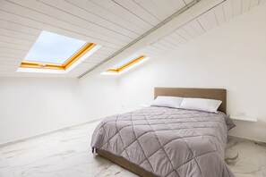 A bedroom with a bed, skylights, and a marble floor. - Cozy Slooping Rooftop (Naples)