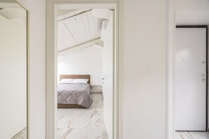 A bedroom with a bed, a door, and a view of the ceiling. - Cozy Slooping Rooftop (Naples)