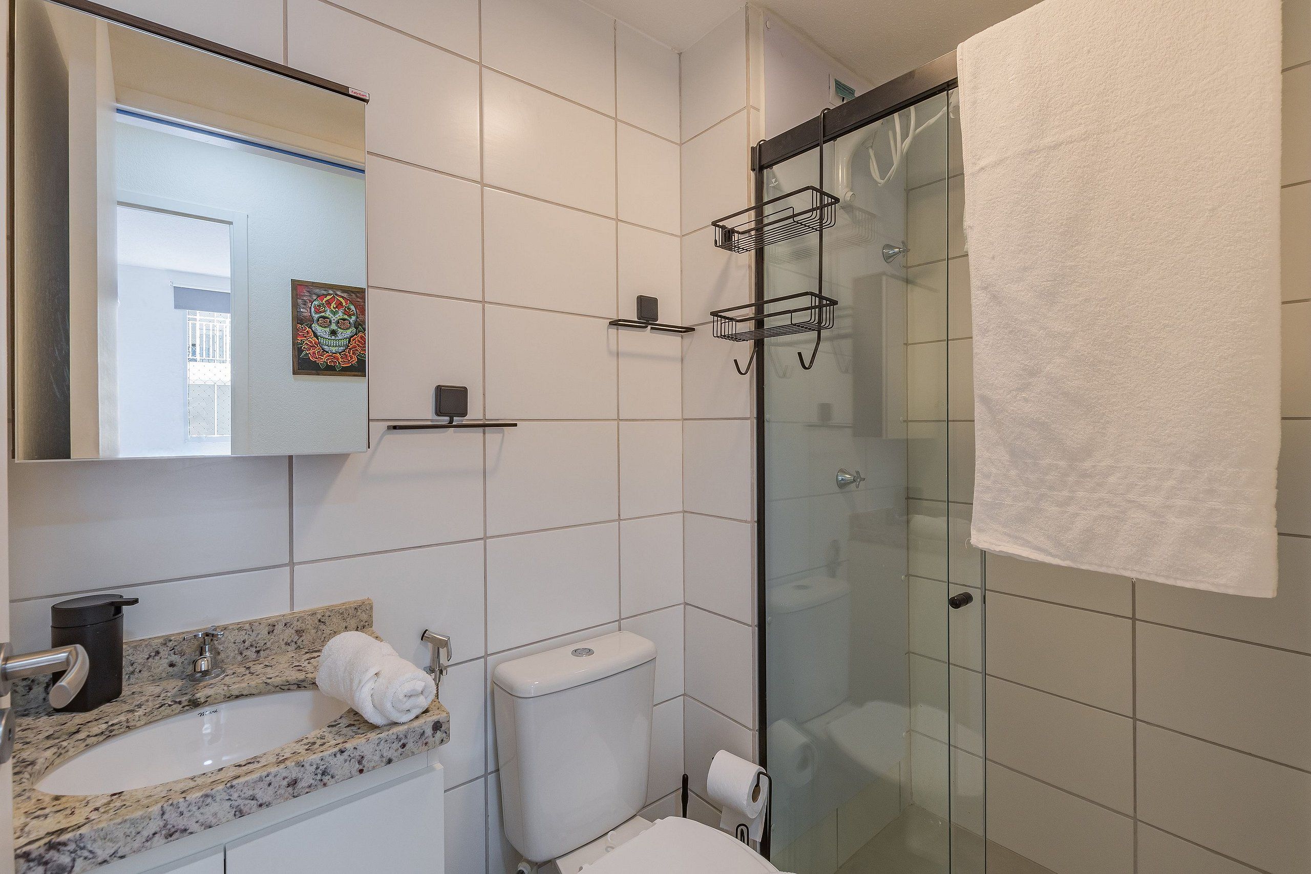 A modern bathroom with a glass shower enclosure, a marble sink, and a toilet.