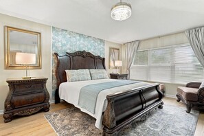 Ein Schlafzimmer mit einem großen Bett, einem verzierten Schmuckkästchen und einer Kandelaber.