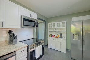 A modern kitchen with stainless steel appliances, white cabinetry, and a marble countertop. - Walk to VSU Campus! Your Escape Away From Home (Petersburg)