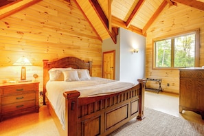 A wooden bedroom with a bed, nightstands, a dresser, and a window with a view of trees. - Game Room, Hot Tub! Retreat 3 Mi to Holiday Valley (Ellicottville)