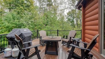 A deck with outdoor furniture, a grill, and propane tanks.