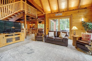 A wooden interior with a staircase, a sofa, a TV, and a sign reading 'Ski Bums Welcome'. - Game Room, Hot Tub! Retreat 3 Mi to Holiday Valley (Ellicottville)