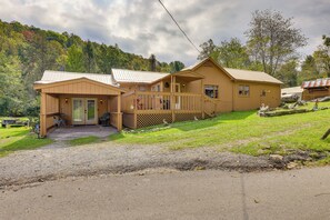 Une cabane en bois à deux étages, dotée d’un porche et d’une petite dépendance attenante.