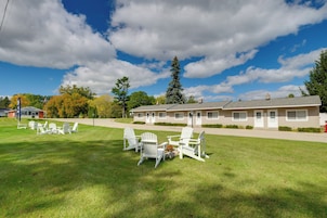 A motel with a grassy lawn and white chairs.