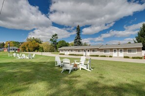 Un motel con césped, mobiliario exterior y cielo despejado.