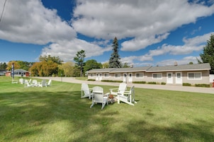 A motel with a grassy lawn, outdoor seating, and a clear sky.