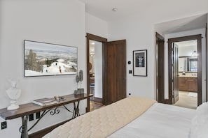 A bedroom with a bed, a TV mounted on the wall, and a view of a snowy landscape. - 201 - Two Bedroom Arrowleaf 2 Condo (Park City)