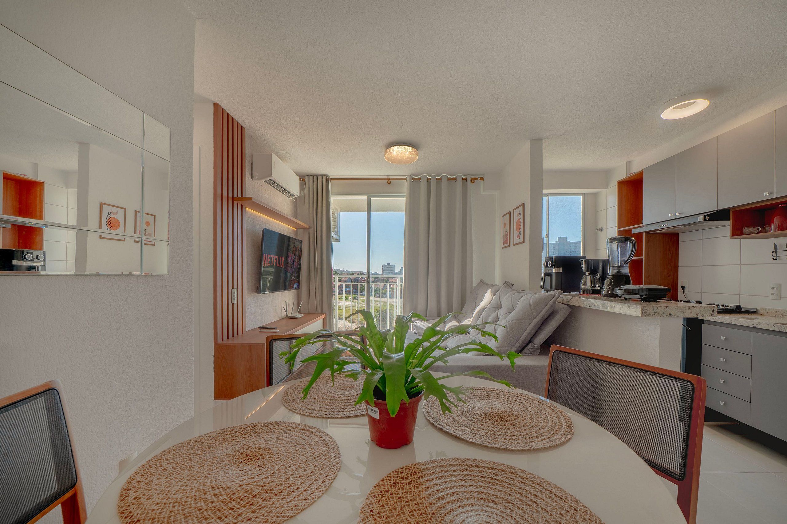 Una cocina moderna con comedor, una planta en maceta y vistas a la ciudad.