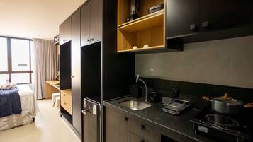 A compact kitchen with a sink, stove, and storage cabinets.