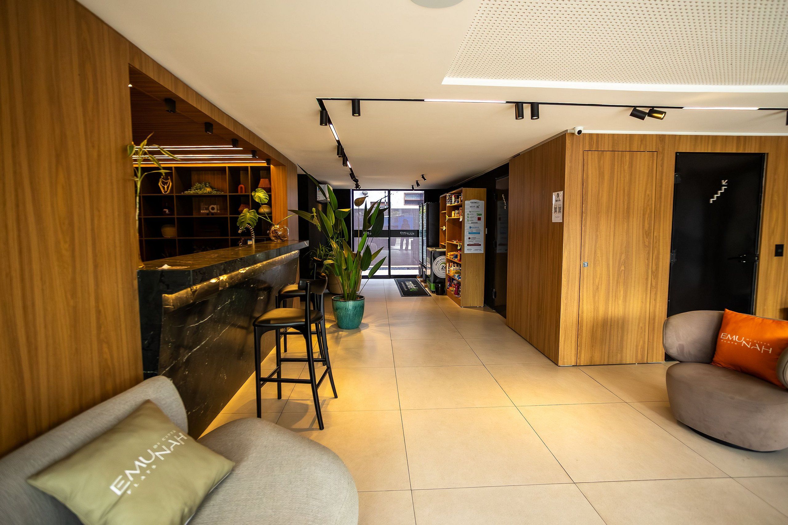 A hotel lobby with a reception desk, seating area, and a view of the street.