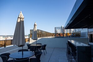 A rooftop terrace with outdoor seating, a view of the city skyline, and a modern architectural design. - Mardisa Design #705 in Cabo Branco by Carpediem (João Pessoa)