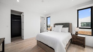 A bedroom with a bed, bedside table, and a window. - The Venice Modern in Venice (Venice)