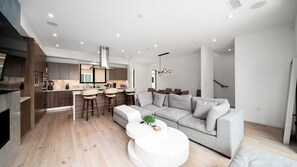 A modern living space with a kitchen, dining area, and a large grey sofa. - The Venice Modern in Venice (Venice)