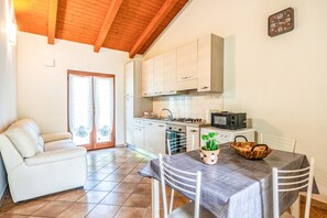 Ein gemütlicher Wohnbereich mit Küchenzeile, Essplatz und Sofa.