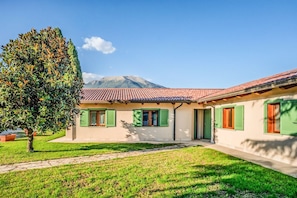 A two-story building with a red-tiled roof, green shutters, and a grassy lawn. - defaultName (Piedimonte San Germano)
