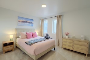 A bedroom with a bed, bedside tables, a dresser, a painting, and a window with curtains. - Leos Cozy Getaway Near SLC Airport & Downtown (Salt Lake City)