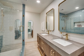 A modern bathroom with two sinks, a shower, and a large mirror. - Putt, Play & Splash! Cedar Creek Lake Getaway (Mabank)