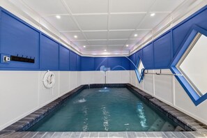 An indoor swimming pool with a tiled floor, surrounded by walls with a blue and white color scheme. - Er61 Smoky Mountain Swim-inn 2 Bedroom Cabin (Pigeon Forge)