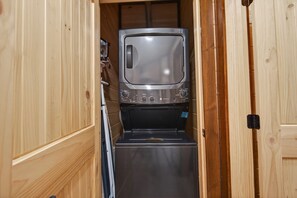 A narrow hallway with a television and a washing machine. - Er61 Smoky Mountain Swim-inn 2 Bedroom Cabin (Pigeon Forge)
