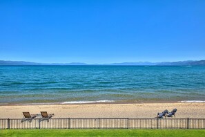 Ein Strand mit Liegestühlen und einer Umzäunung.