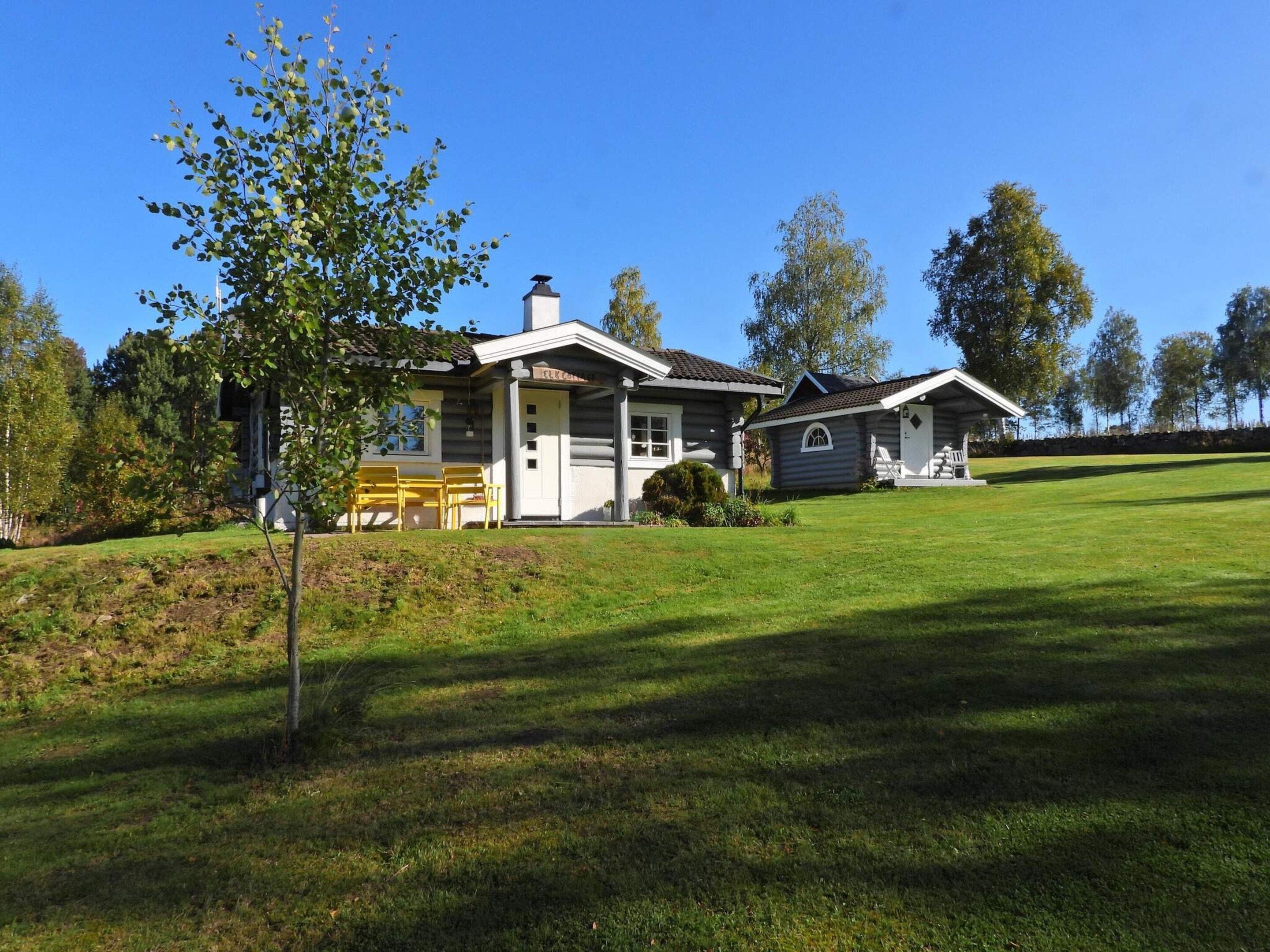 A two-story log cabin with a porch and a separate garage.
