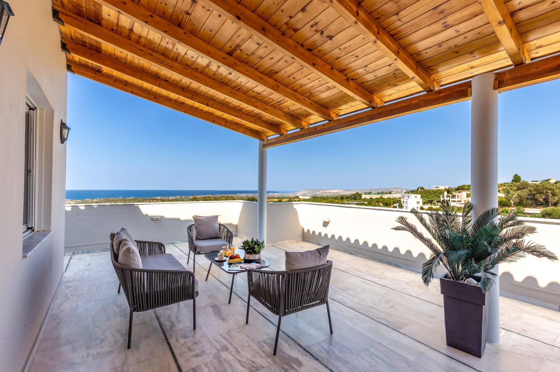 A covered outdoor seating area with a view of the sea.