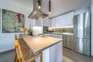 A modern kitchen with a central island, stainless steel appliances, and a minimalist design. - Villa Grand Barbati Beach by Villa Plus (Mparmpati)