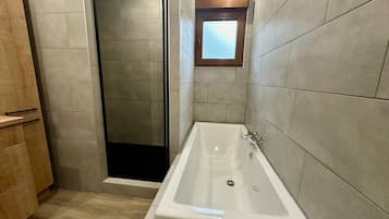 Une salle de bain moderne avec une douche à l’italienne, une baignoire sur pieds et un meuble en bois.