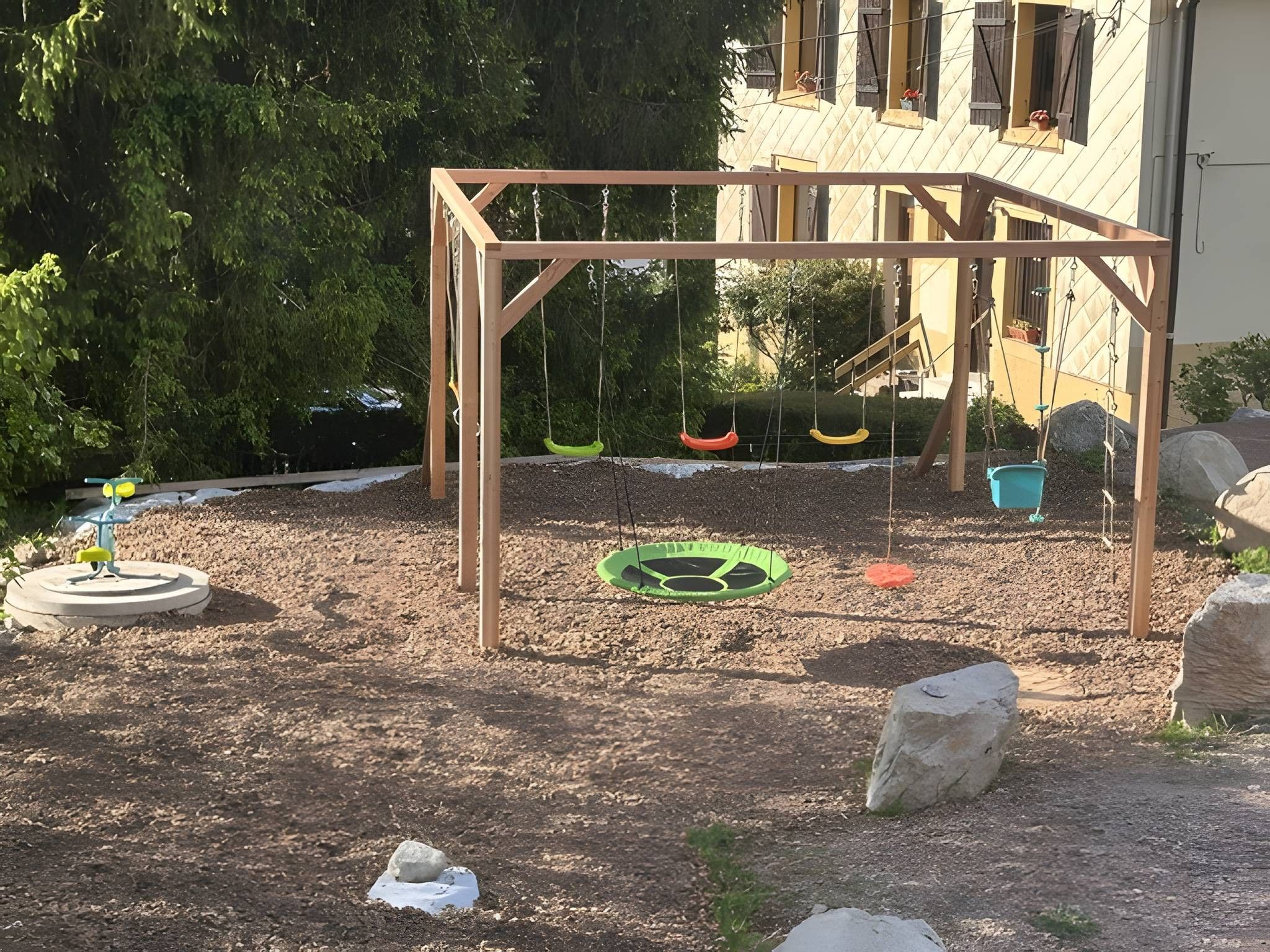Ein Spielplatz mit einer Holzschaukel und einer Reifenschaukel.
