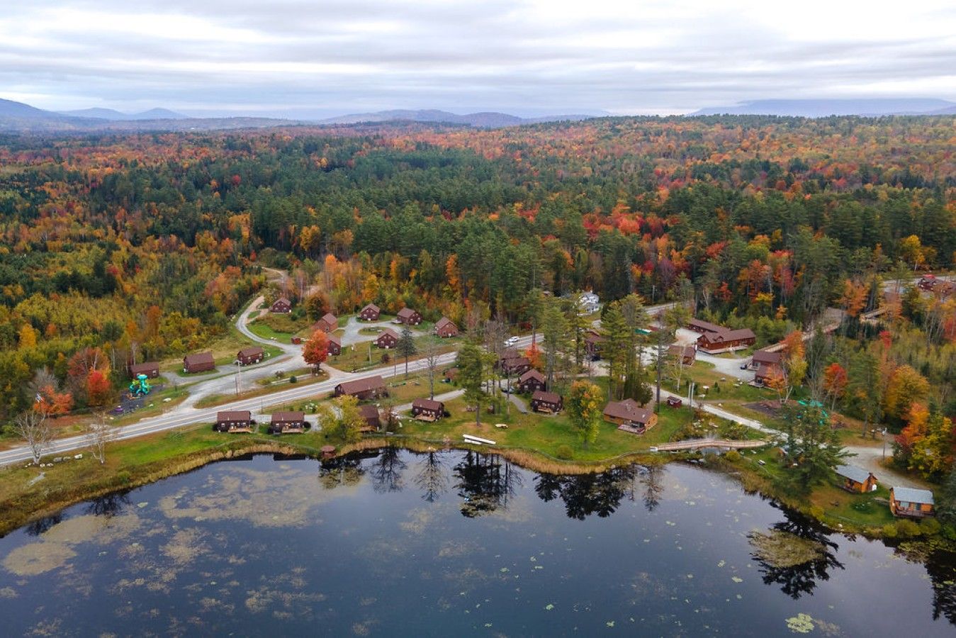 Une communauté riveraine, avec des maisons, des routes et une forêt en arrière-plan.