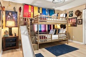 A bunk bed room with a slide, posters, and a small desk. - 6BR Windsor Hills Home Near Disney With Pool (Kissimmee)
