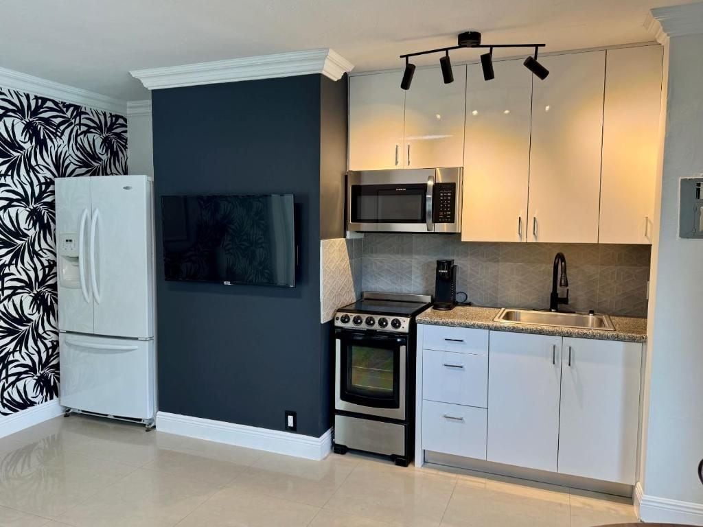 A modern kitchen with a built-in microwave, oven, and a large refrigerator.