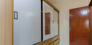 A room with a wardrobe, a mirror, and a wooden door. - Casa em Angra dos Reis próxima a Praia (Angra dos Reis)