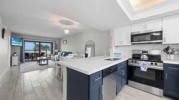 A modern kitchen with a central island, a microwave, an oven, and a dishwasher.