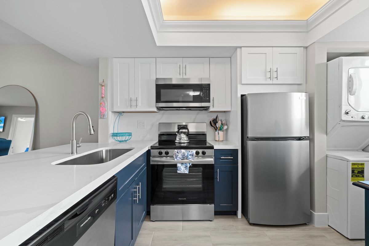 A modern kitchen with white cabinets, stainless steel appliances, and a dishwasher.