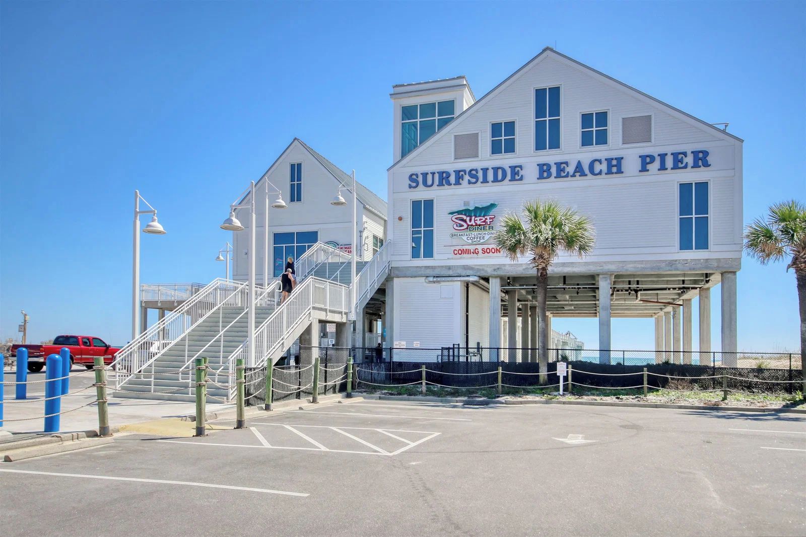 Un bâtiment sur lequel on peut lire l’inscription « Surfside Beach Pier » et un panneau indiquant un restaurant appelé « Surf Diner ».