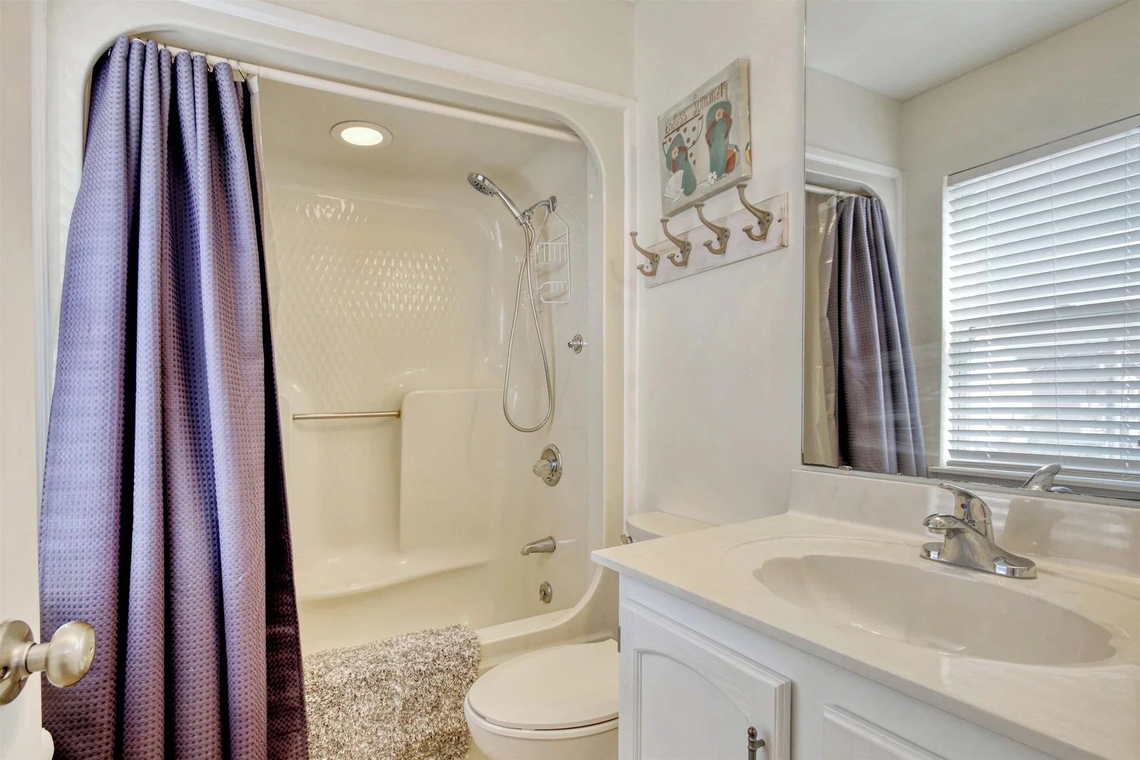 Une salle de bain avec douche, toilettes et lavabo.