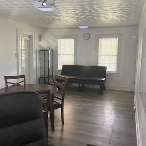 A room with a dining table, chairs, a bench, and two windows with blinds. - Welcoming 7-bedroom house with AC in charming Salisbury (Salisbury)