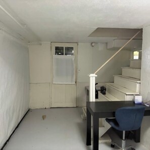 Ein kleines Zimmer mit Schreibtisch, Stuhl und einer Treppe zu einer weiteren Ebene.