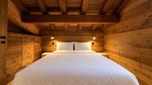 A wooden room with a bed, two wall-mounted lights, and a wooden ceiling. - NEW! Chalet Eagle - LES GETS: ski-in/ski-out, fireplace, superb view (Les Gets)