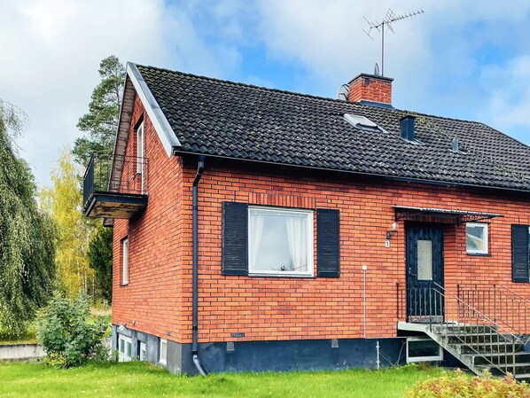 A red brick house with a black roof, a small front porch, and a satellite dish. - 8 Person Holiday Home in Stockaryd (Stockaryd)